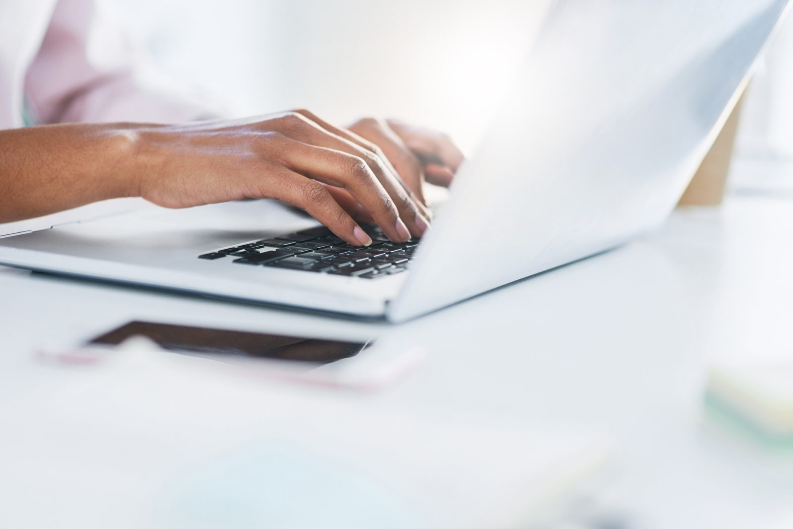 Closeup shot of an unrecognizable woman working on a laptop in an office